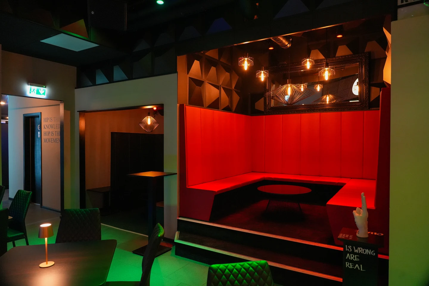 Gastraum der Bar The Nineties mit Tischen und beleuchteter Theke